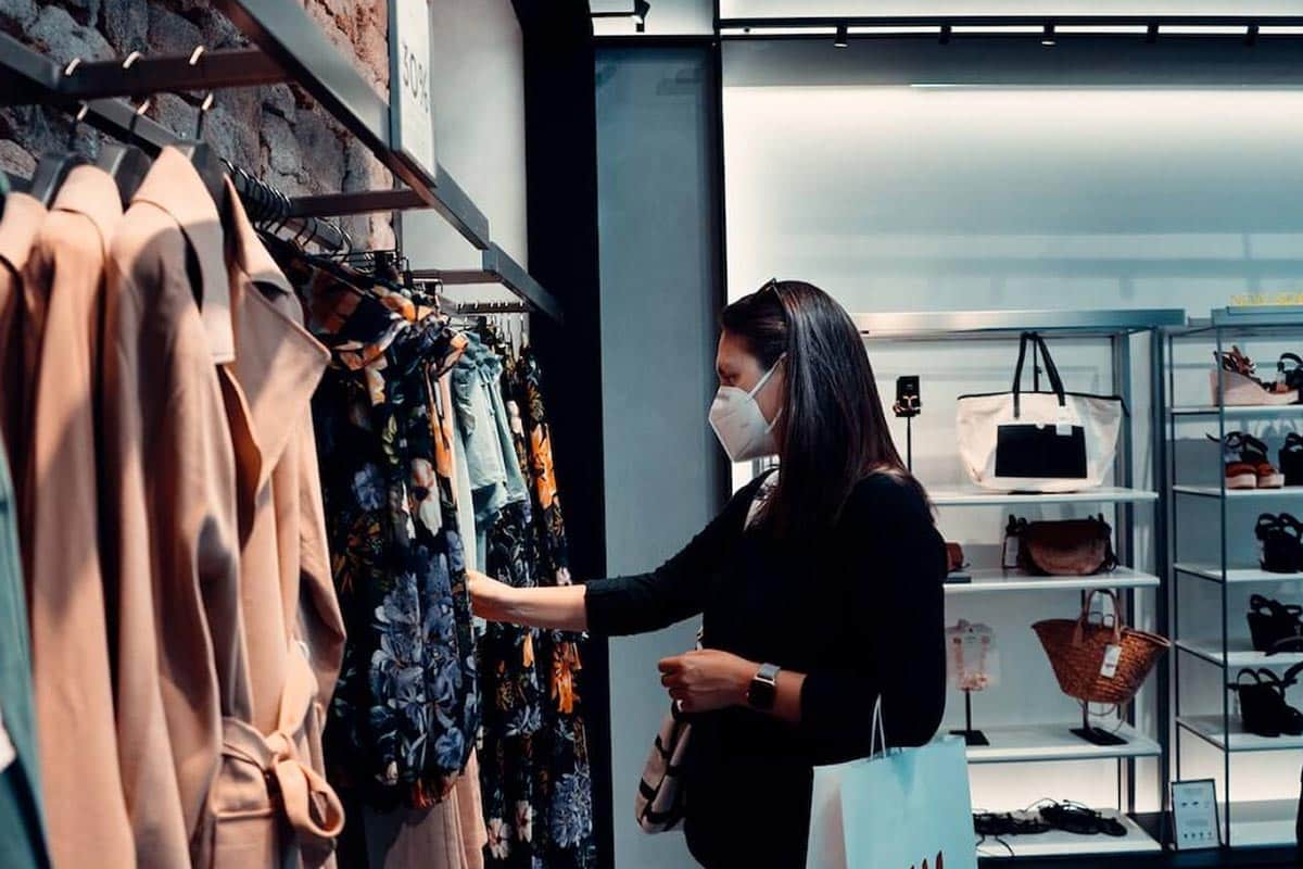 woman shopping for clothes with a mask on, pandemic