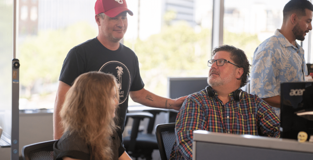 Inside sales team in a collaborative office environment discussing actionable B2B strategies, customer engagement, and effective sales tips to enhance sales performance and address pain points. Three team members collaborating on inside sales strategies, enhancing sales performance with expert insights and teamwork. This image captures a typical inside sales environment where sales reps work together to optimize techniques, discuss customer engagement, and improve sales effectiveness. Keywords like inside sales tips, inside sales advice, and inside sales outsourcing are relevant for achieving success in B2B sales.