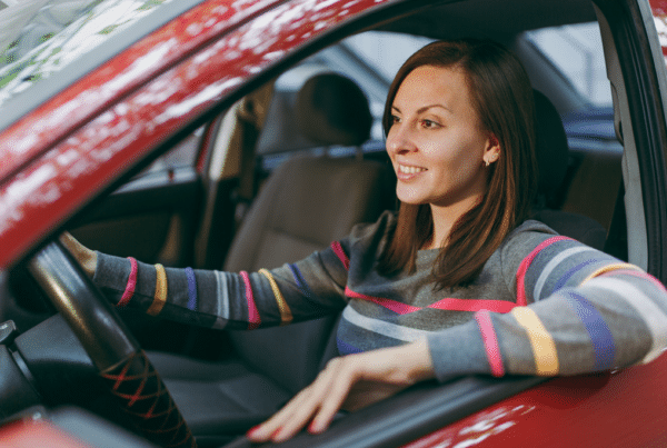 Lady driving a red car