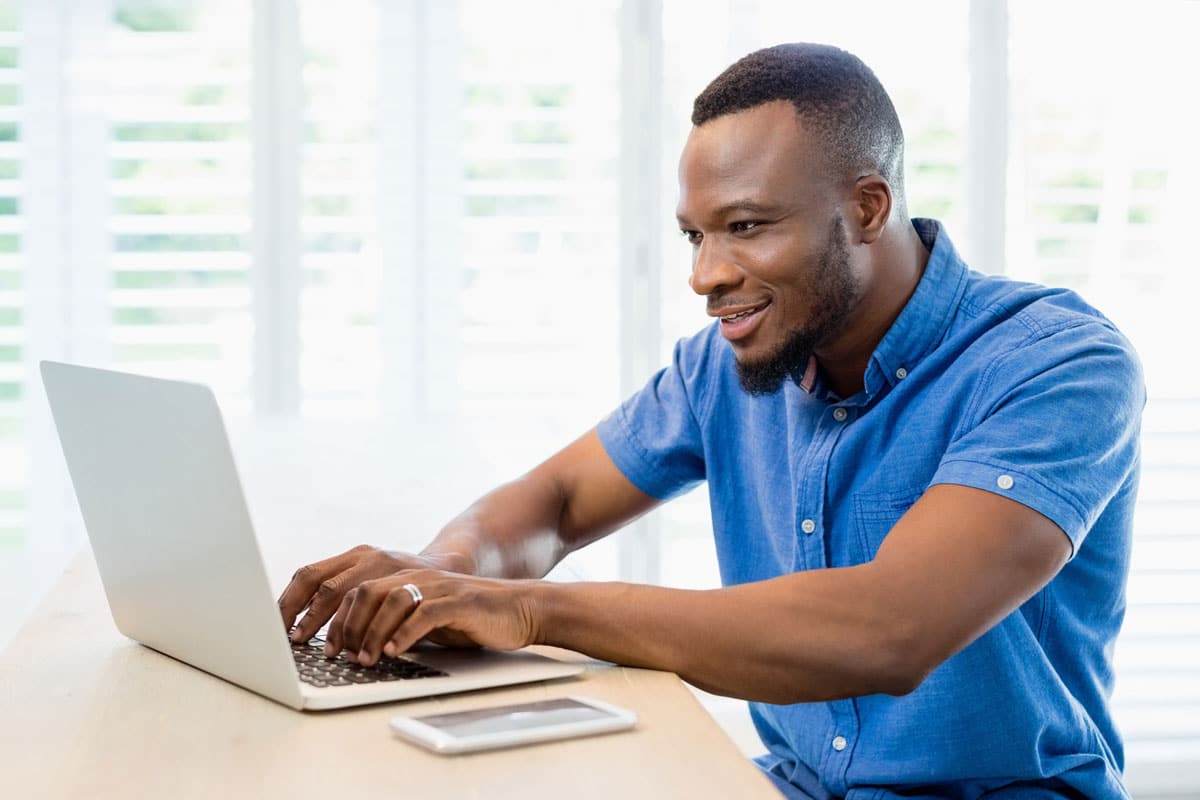 Young professional African American man looking at laptop