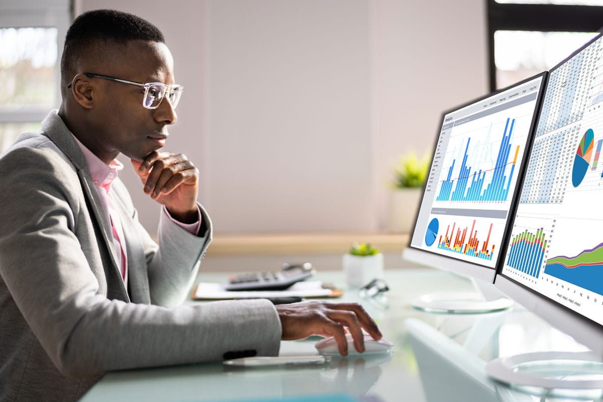 African American business man looking at charts on laptop