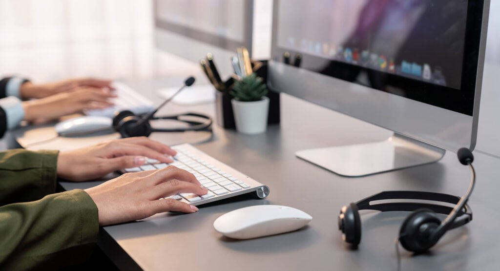 Hands typing on a keyboard, representing efficient customer service outsourcing services. This image highlights the operational excellence of outsourced call center services, emphasizing seamless digital processes and support. Companies looking for customer care outsourcing, customer service outsourcing solutions, and contact center outsourcing companies can achieve cost-effective scalability and customer satisfaction by partnering with top customer service outsourcing companies like Harte Hanks. It’s a visual representation of modern outsourcing, bridging technology and human service to provide unmatched customer care for businesses in any industry.