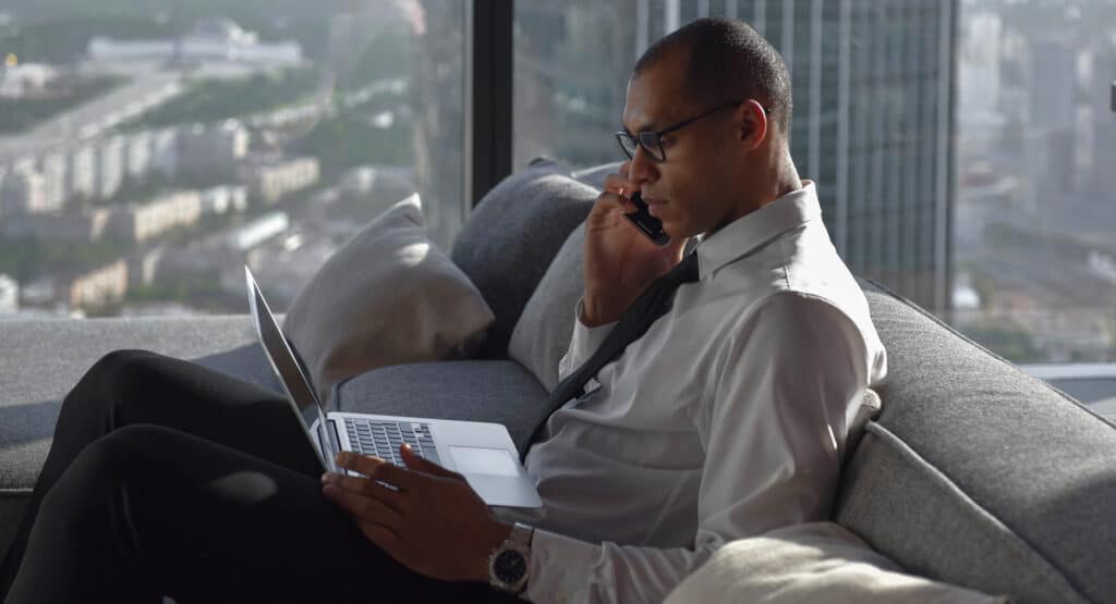 Business professional engaged in relationship marketing call while working on a laptop. Showcasing Harte Hanks' relationship marketing services that build customer loyalty and advocacy by leveraging personalized, data-driven marketing strategies.