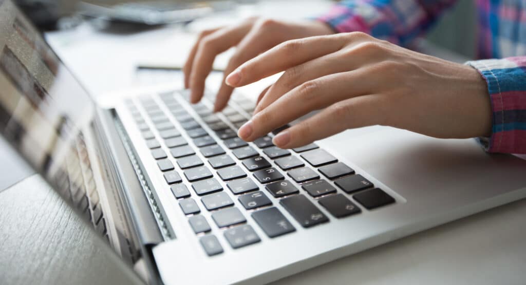 Hands typing on a laptop keyboard, representing Harte Hanks' B2C email marketing services. As a top email marketing agency, we specialize in crafting targeted email campaigns that drive engagement and maximize ROI. Perfect for brands looking for expert email marketing services to reach and retain customers effectively.
