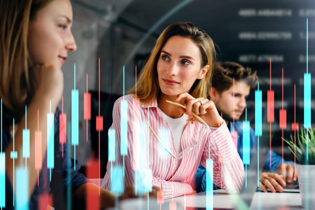 New market expansion strategy concept with professionals discussing go-to-market strategies, demand generation, and international growth opportunities. Overlay of stock market data represents global business expansion.