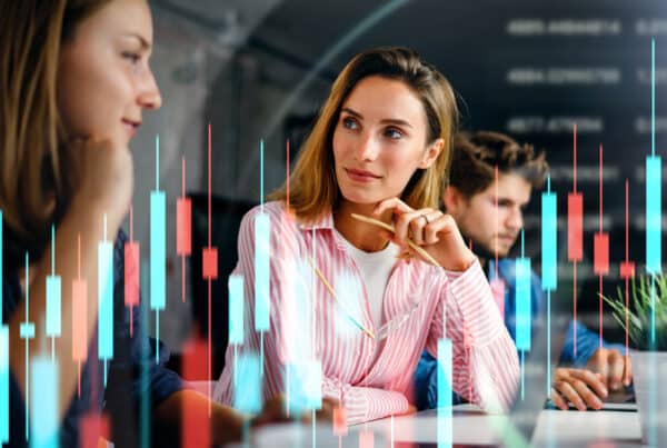 New market expansion strategy concept with professionals discussing go-to-market strategies, demand generation, and international growth opportunities. Overlay of stock market data represents global business expansion.