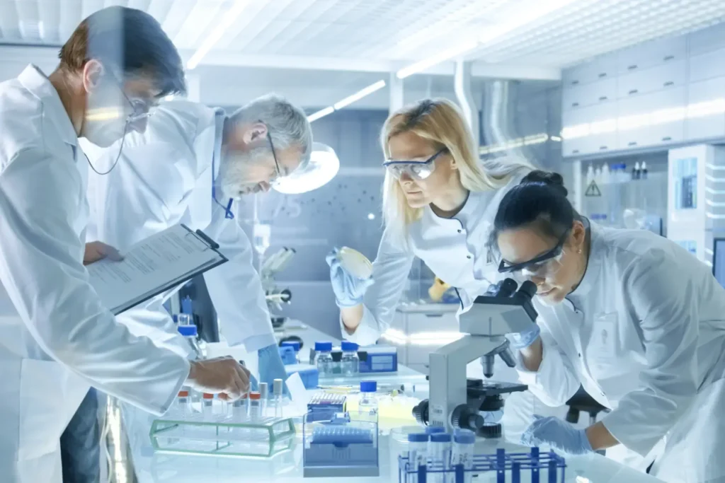 Research team in a laboratory collaborating with scientific equipment to analyze samples and record results